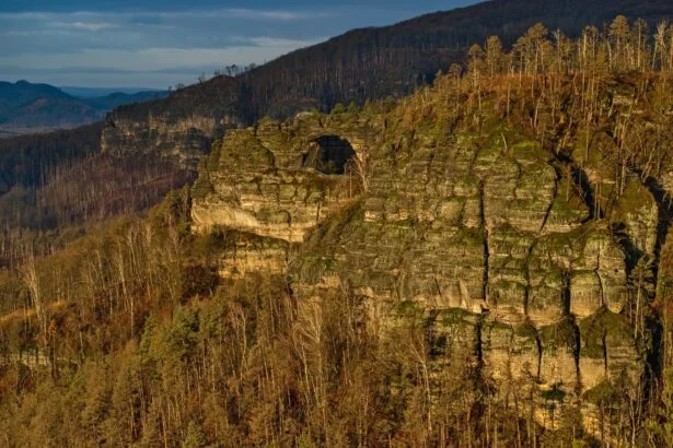 Pískovcová Pravčická brána ve skalní stěně nad lesy Českého Švýcarska