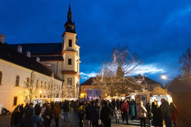 Adventní trh na Zámeckém návrší v Litomyšli za soumraku, v pozadí piaristický chrám
